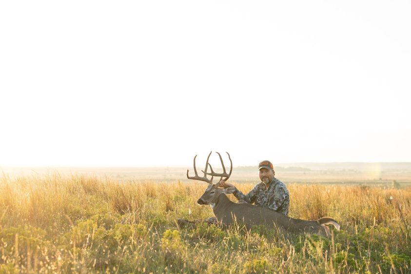 hunter with large buck in fall