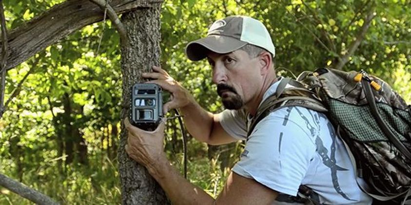 Man setting up a trail cam