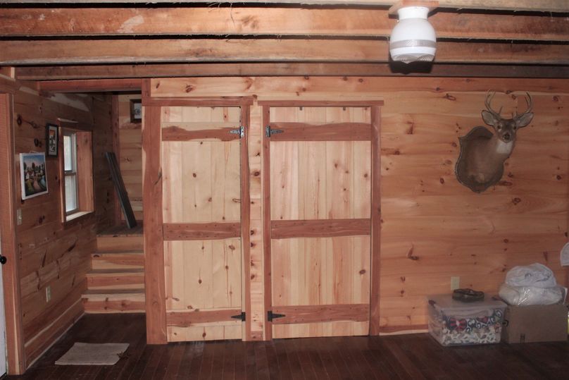 012 open living room area with stairway to upstairs, doorway understair storage and bathroom 