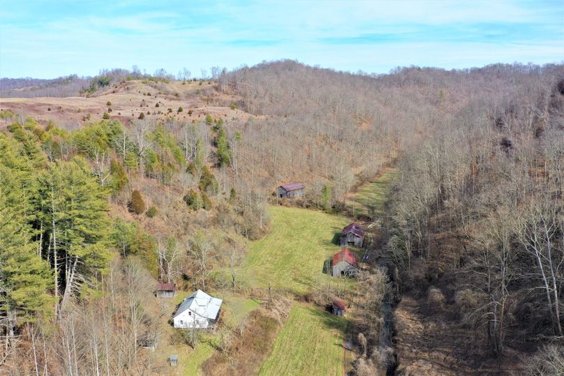 001 drone shot near the northwest entry to the property showing 1 of the 2 farmhouses located on the property
