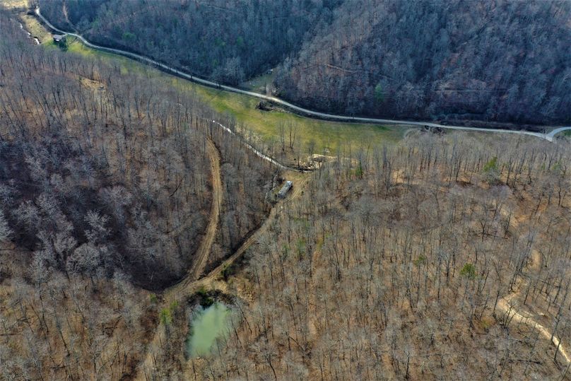 004 gorgeous aerial drone shot of the pond, creek, fields, and main pavement road