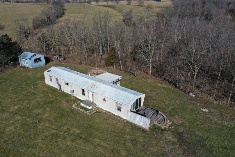 027 low elevation aerial drone shot of the mobile home at the southwest corner of the property