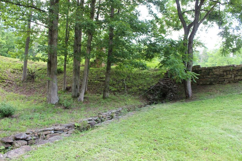 036 beautifully hand laid stone creek banks as you enter the property alongside driveway