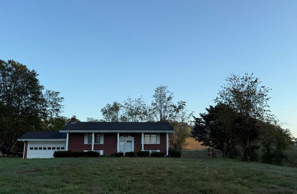 002 Front view of the 3000 Sq foot brick home with two-car garage in a quiet country setting.