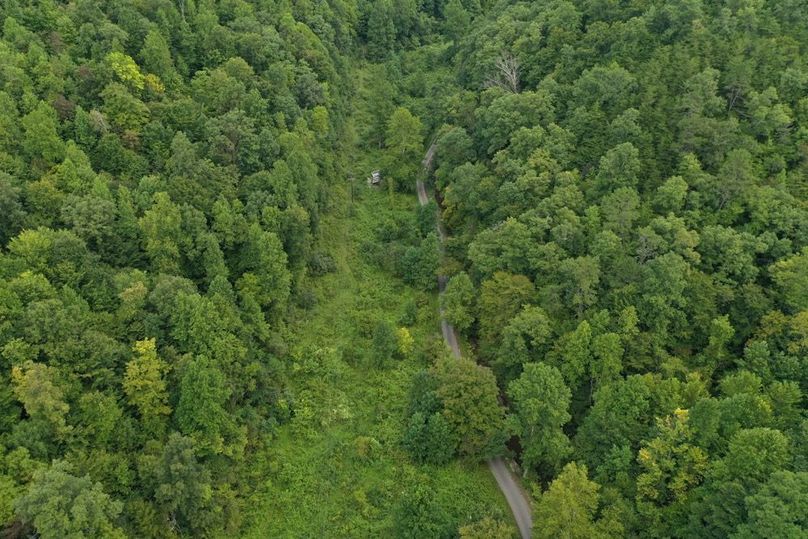 002 low elevation drone shot of the valley with the field area along the road