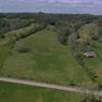 001 Stunning aerial perspective capturing the full character of the property. A gently rolling pasture, scenic surroundings, and excellent accessibility