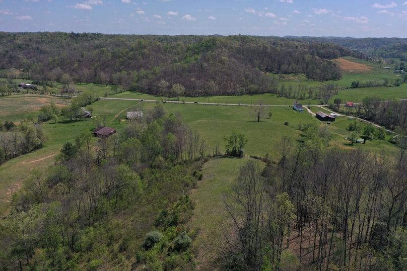 016 Rear aerial perspective showcasing the full depth of the property, open ground, and road frontage