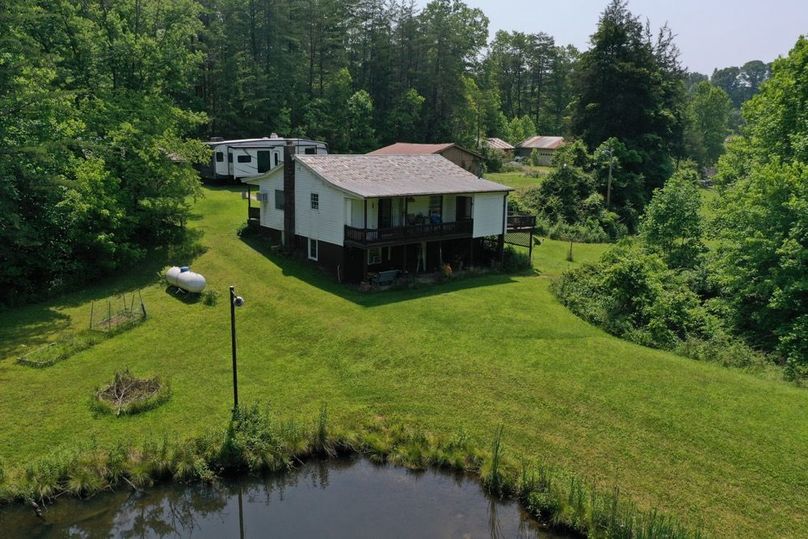 027 low elevation drone shot of the home from the dam of the pond